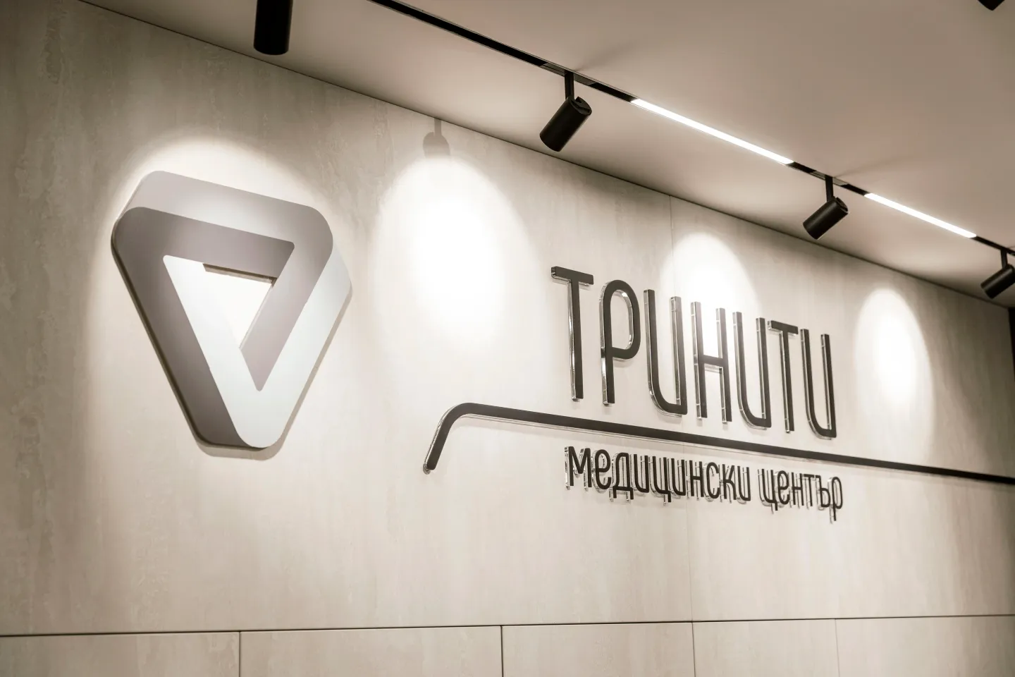 Логото на Медицински център „Тринити“ на стената в центъра